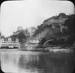 Skioptikonbild med motiv av vy över Meersburg am Bodensee. Hotel Seehof vid hamnen.
Bilden har förvarats i kartong märkt: Resan 1906. Meersburg 4. Schaffhausen 4.