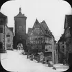 Skioptikonbild med motiv av Plönlein, det lilla torget i Rothenburg ob der Tauber.
Bilden har förvarats i kartong märkt: Vårresan 1910. Rothenburg. XXX. Text på bild: 