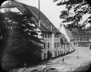 Skioptikonbild med motiv av A. Strobelbergers möbelfabrik längs gatan Glatten i Rostock.
Bilden har förvarats i kartong märkt: Resan 1912. Rostock. Text på bild: 