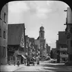 Skioptikonbild med motiv från Segringer strasse i Dinkelsbühl med Stadtpfarrkirche St. Georg i bakgrunden.
Bilden har förvarats i kartong märkt: Resan 1911. Dinkelsbühl 9. VII. Text på bild: 