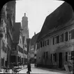 Skioptikonbild med motiv av Luckengasse 15 med Gasthaus zum goldenen Löwe i Nördlingen, med St. Georgs Kirche i bakgrunden.

Bilden har förvarats i kartong märkt: Resan 1911. Nördlingen 10. X.