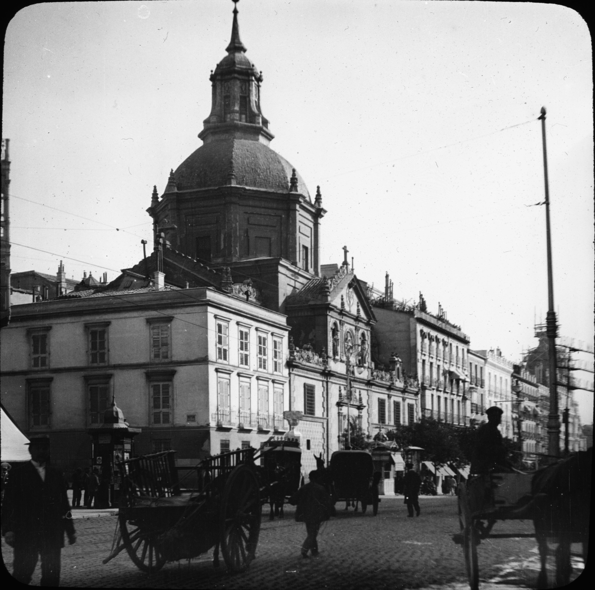 Skioptikonbild med motiv av Iglesia de las Calatravas, Madrid (Spanien).
Bilden har förvarats i kartong märkt: Höstresan 1910. Madrid 9. N:2. Text på bild: "Calle de Alacadá".