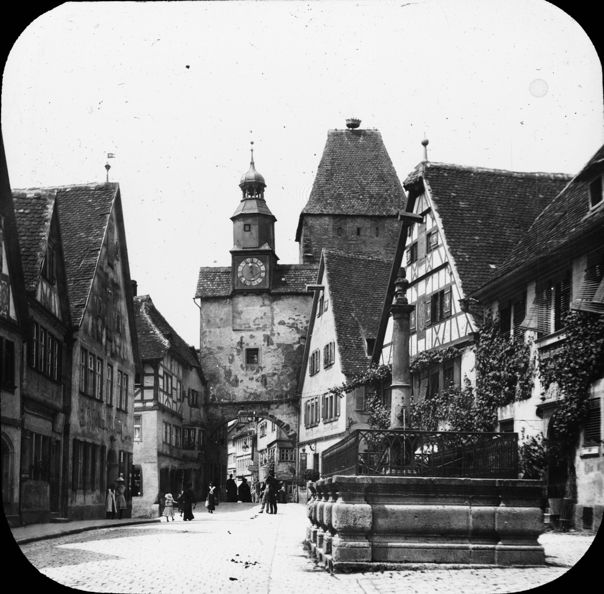 Skioptikonbild med motiv från gatan Rödergasse som passerar genom Markusturm, Rothenburg.

Bilden har förvarats i kartong märkt: Vårresan 1910. Rothenburg. XXVII. Text på bild: "Röder str. Markusturm".