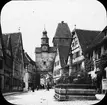 Skioptikonbild med motiv från gatan Rödergasse som passerar genom Markusturm, Rothenburg.

Bilden har förvarats i kartong märkt: Vårresan 1910. Rothenburg. XXVII. Text på bild: 