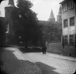 Skioptikonbild med motiv från gata vid Hildesheim Dom.
Bilden har förvarats i kartong märkt: Vårresan 1909. Hildesheim 9. VI. Text på bild: 