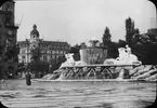 Skioptikonbild med motiv av Wittelsbacherbrunnen i München.
Bilden har förvarats i kartong märkt: Höstresan 1909. München 8. No:26. Text på bild: 