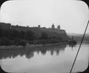Skioptikonbild med motiv från färd längs Donau. Vy över benediktiska klostret Stift Melk.
Bilden har förvarats i kartong märkt: Höstresan 1909. Donau 8. No:5.