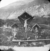 Skioptikonbild med motiv av religiöst monument längs vägen norr om Castellbell, i sydliga Tyrolen.
Bilden har förvarats i kartong märkt: Höstresan 1909. Trient 8. No: 22. Text på bild: 