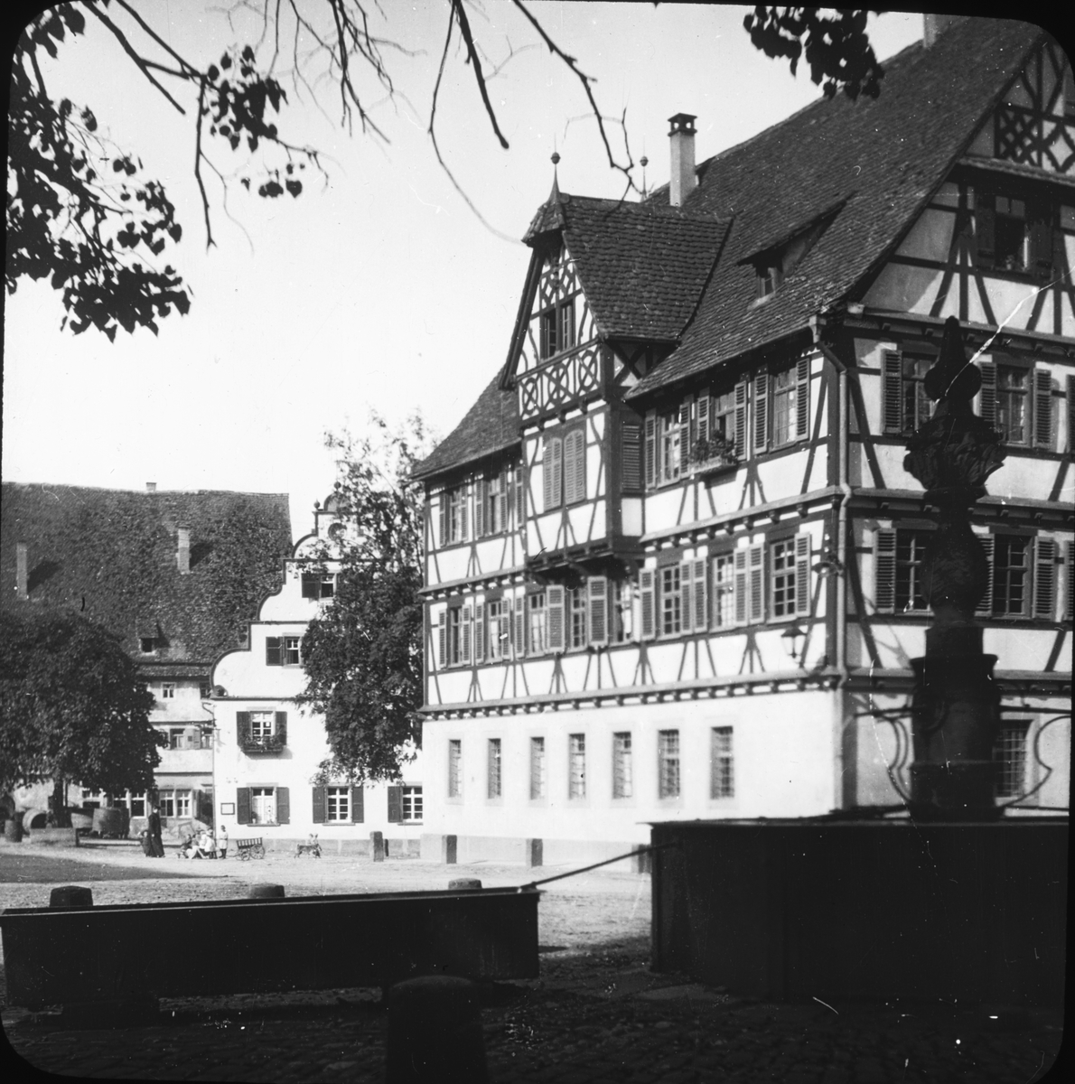 Skioptikonbild med motiv från gården till det cistercianskta munkklostret i Maulbronn.
Bilden har förvarats i kartong märkt: Resan 1908. Maulbronn 8. Text på bild: "Klostergården".