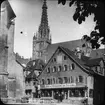 Skioptikonbild med motiv av bageri i Reutlingen med Evangelische Kirche Reutlingen i bakgrunden.
Bilden har förvarats i kartong märkt: Resan 1906. Reutlingen 2. Vägen till Tübingen 4.