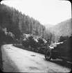 Skioptikonbild med motiv från bilfärd längs landsväg i bergsområdet Schwartzwald.
Bilden har förvarats i kartong märkt: Resan 1908. Schwartzwald. Gersbach. Herrenalb 8.