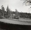 Utsikt från prästgården mot Mo kyrka. Prästgården var tidigare verkstadsbyggnad vid Flors Linnefabrik, Hälsingland. I sluttningen nedanför kyrkan låg små jordstugor där linet bereddes och vävning ägde rum.