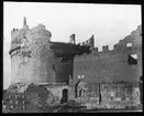 Skioptikonbild från institutionen för fotografi vid Kungliga Tekniska Högskolan. Motiv föreställande Caecilia Metellas grav (Mausoelo di Cecilia Metella). Byggd första århundradet före Kristus. Ett av de mest välbevarade monunenten längs Via  Appia.  Bilden är troligen tagen av John Hertzberg under en resa i Europa.