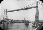 Skioptikonbild med motiv av bron Le Pont Transbordeur i Rouen. Bron byggdes  1899 och stod fram till 1940 då den bombades av franska trupper tyska armén.
Bilden har förvarats i kartong märkt: Resan 1908. Rouen 7. II. Text på bild: 