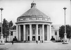 Skioptikonbild med motiv från yrkesinspektionens undersökningar på olika arbetsplatser. Internationella hygienutställningen 1911 i Dresden. Centrala utställningshallen 