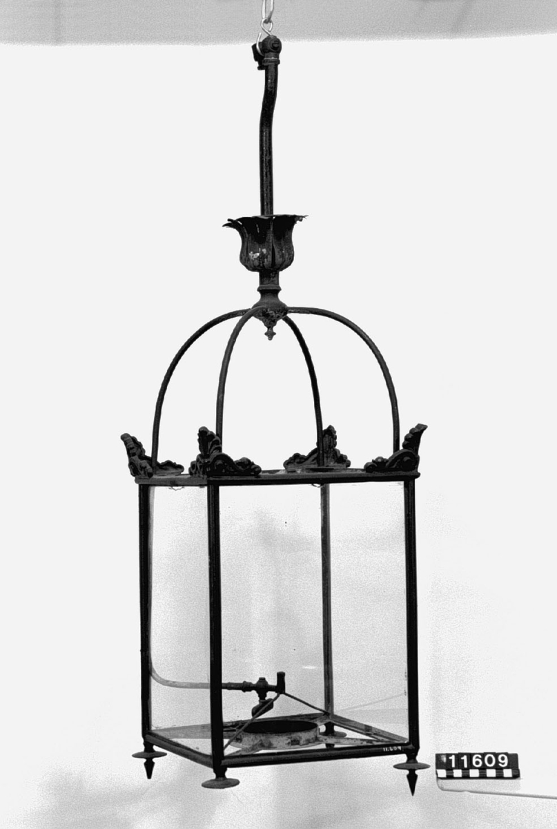 Gaslykta med ram av grönmålad metall och glasfönster.