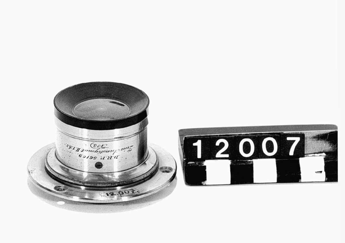Objektiv, anastigmat, för kamera, med irisbländare. Graverat: "D.R.P. 56109 Zeiss Anastigmat II 1:6:3 N:o 3", och "Voigtländer & Sohn Braunschweig N:o 45469". Brännvidd: 14 cm.