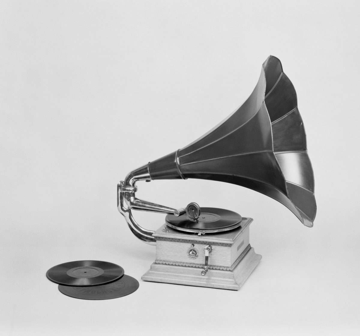 Grammofon, med enkelfjäderverk och jättetratt av lackerad plåt. Höjd: 700 mm med tratt. Lösa delar: Tratt och vev.
Består av
TM14615:1 Grammofon
TM14615.2