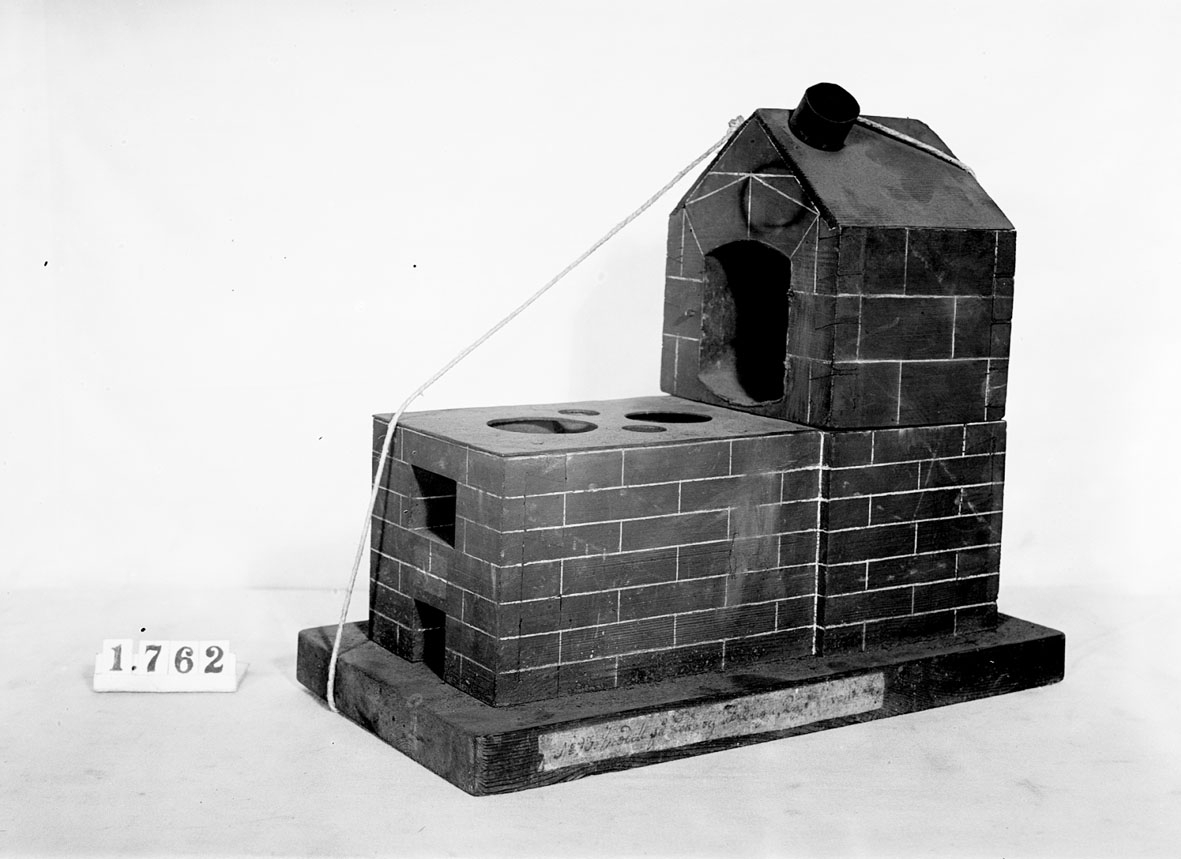 Modell av kok- och stekugn. Text på föremålet: "N:o 93. Modell på Kok- och Stekugn. Tysk invention."
