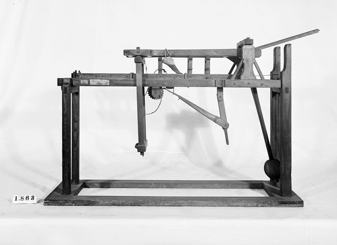 Modell av handdriven brädsåg. Text på föremålet: "Brädsåg för hand med ställning. B-d-11 N:o 175".