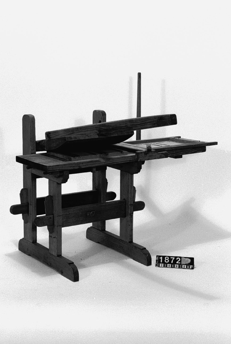 Modell av press för linjering av papper. Text på föremålet: "N:o 180. F-a-g-2 XIII. 25" (texten delvis försvunnen).