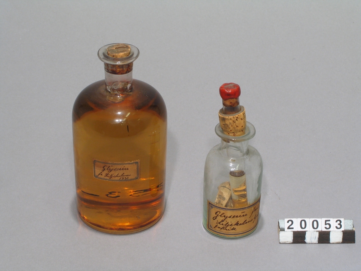 Två prov på glycerin. I provrör och flaska av glas med etiketter: "Glyserin från Liljeholmens ljusfabrik". "Glycerin fr. Liljeholmen. 1881".