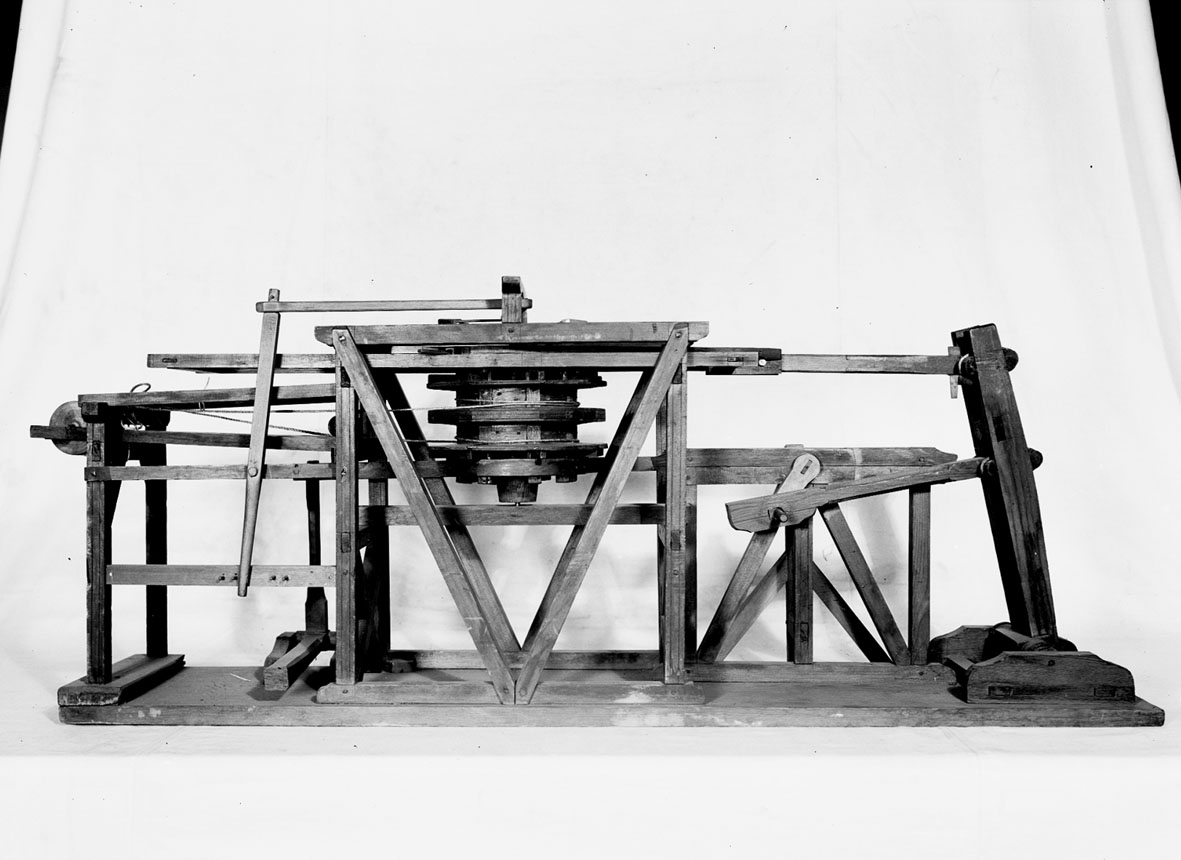 Modell av uppfordringsverk. Text på föremålet: "XII.32". I Jonas Norbergs förteckning från 1779 beskrivs modellen på följande sätt: "Modell som visar, huru dubbla vefvar med stånggång nyttjas vid upfordringsvärck."