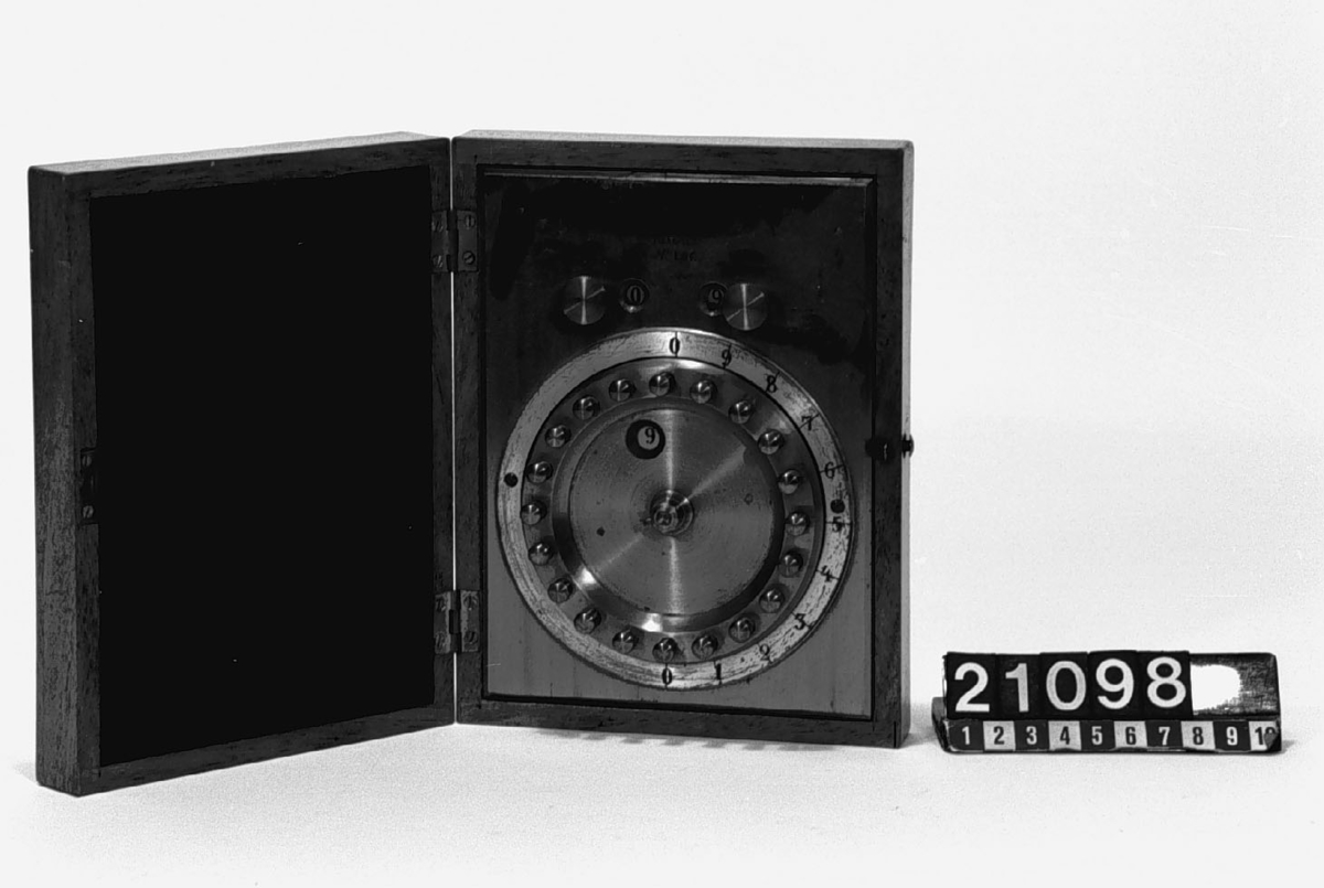 Räknemaskin för addition och multiplikation. "C.H.J. Palmcrantz Patent Nr 106". Monterad i ram av mässing med botten, tre skruvar saknas, i låda av mahogny. Etuiet: 185 x 140 x 50.