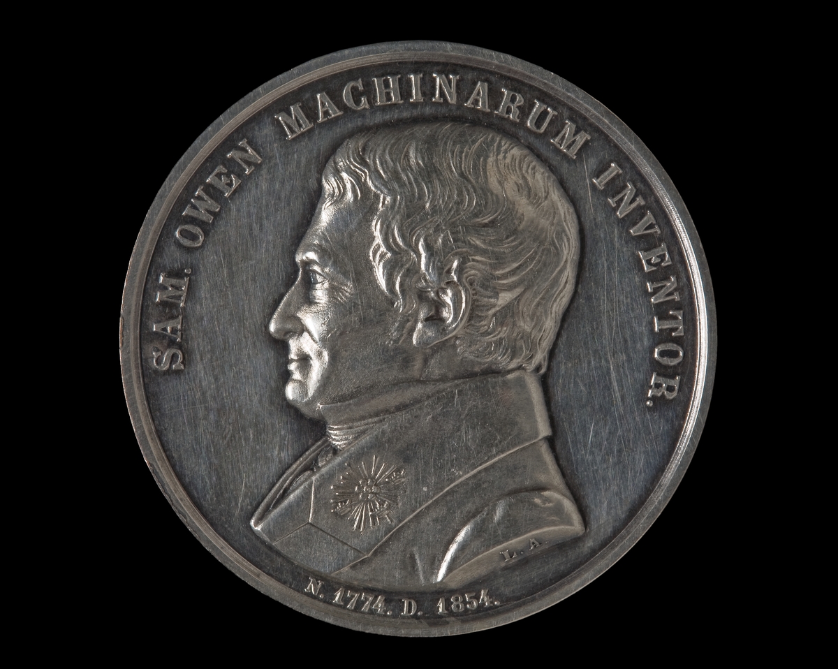 Medalj i silver över Samuel Owen (1774, 1854), slagen av Vetenskapsakademien. Åtsidan: porträtt vänster profil. Text" SAM. OWEN MACHINARUM INVENTOR." Frånsidan: Ångfartyg. Text "NOVAS DEDIT ALAS. SOCIO MECHANICO REG. ACAD. SC. SVEC. MDCCCLXXV."