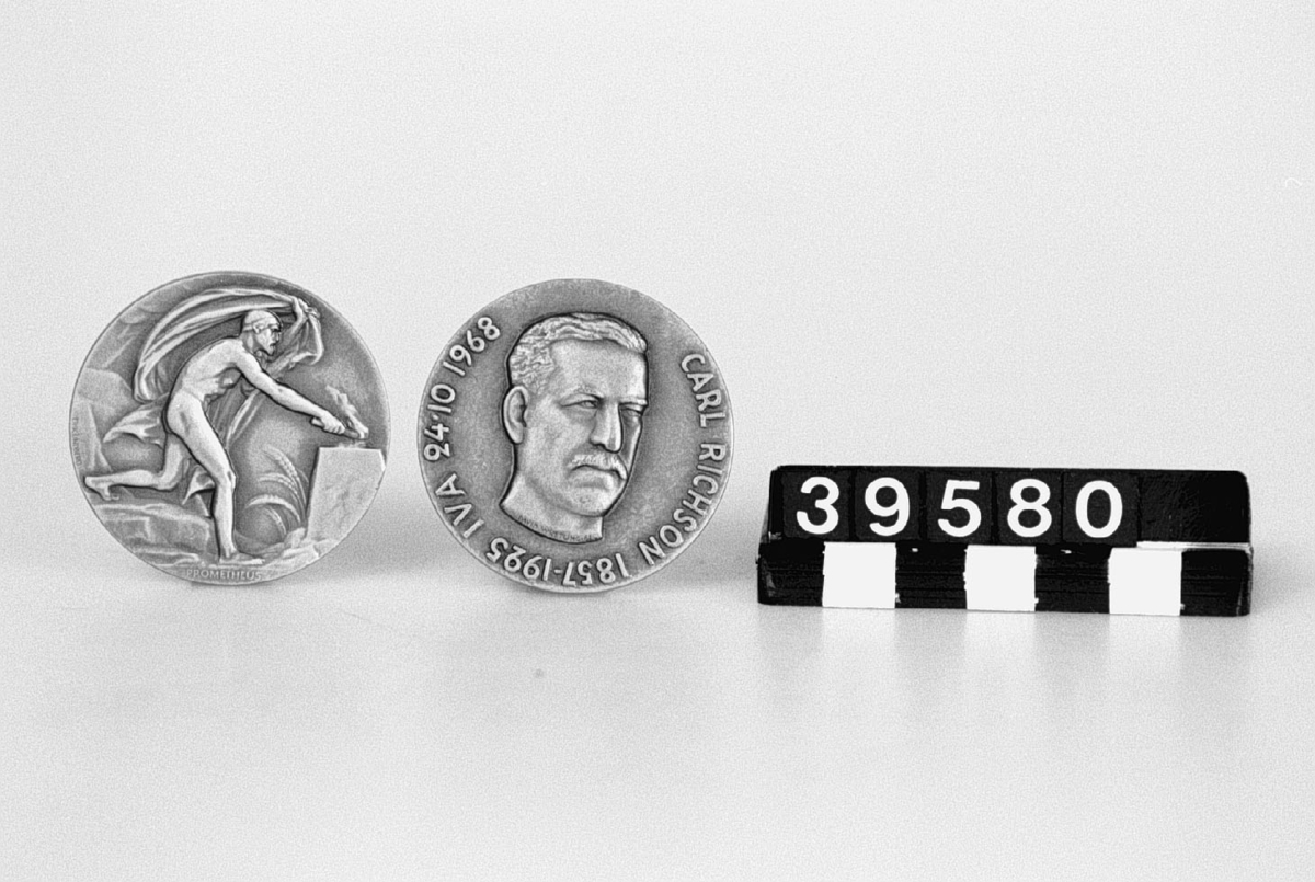 Medalj i brons. Åtsidan: Porträtt, vänsterprofil av L.M.Ericsson, text runt porträttet: "Lars Magnus Ericsson Född 1846 Död 1926 IVA 24 oktober 1931". Frånsidan: Prometheus.