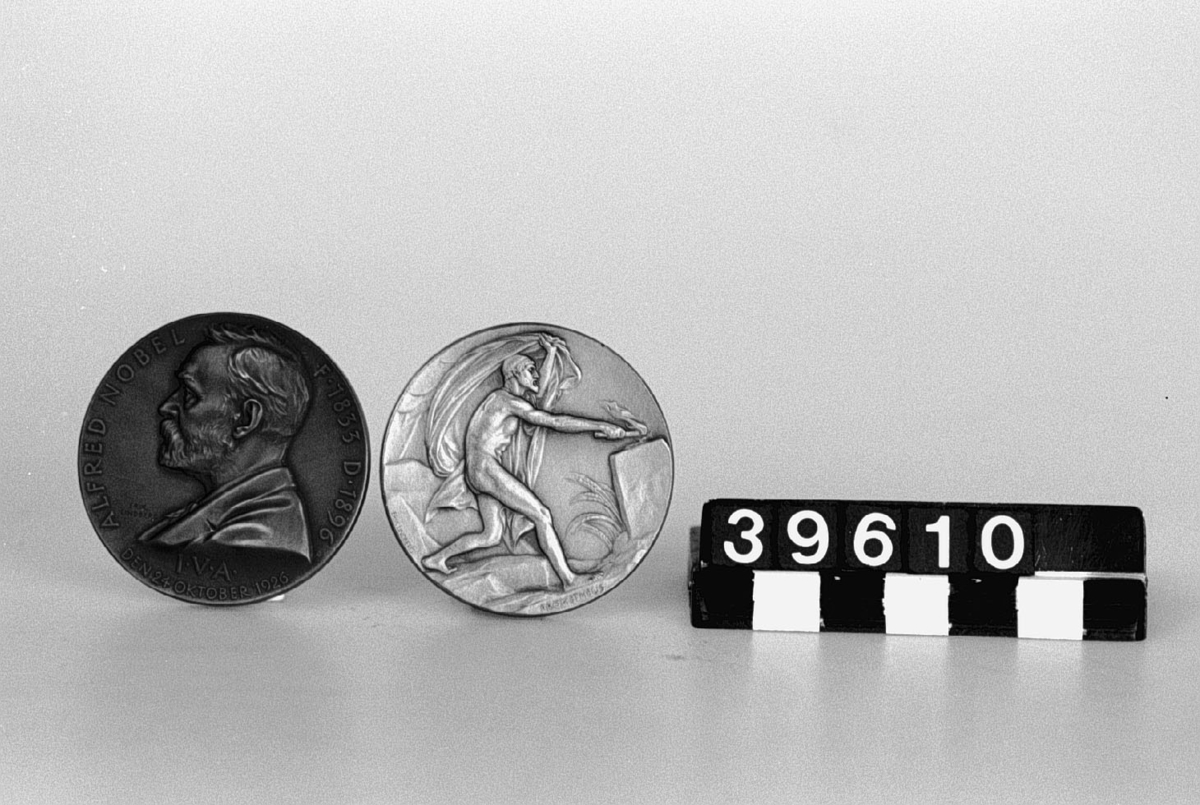 Medalj av brons. Åtsidan: Porträtt, vänsterprofil av A. Nobel, text runt porträttet "Alfred Nobel. F. 1833 D. 1896 IVA Den 24 oktober 1926". Baksida: Prometheus.