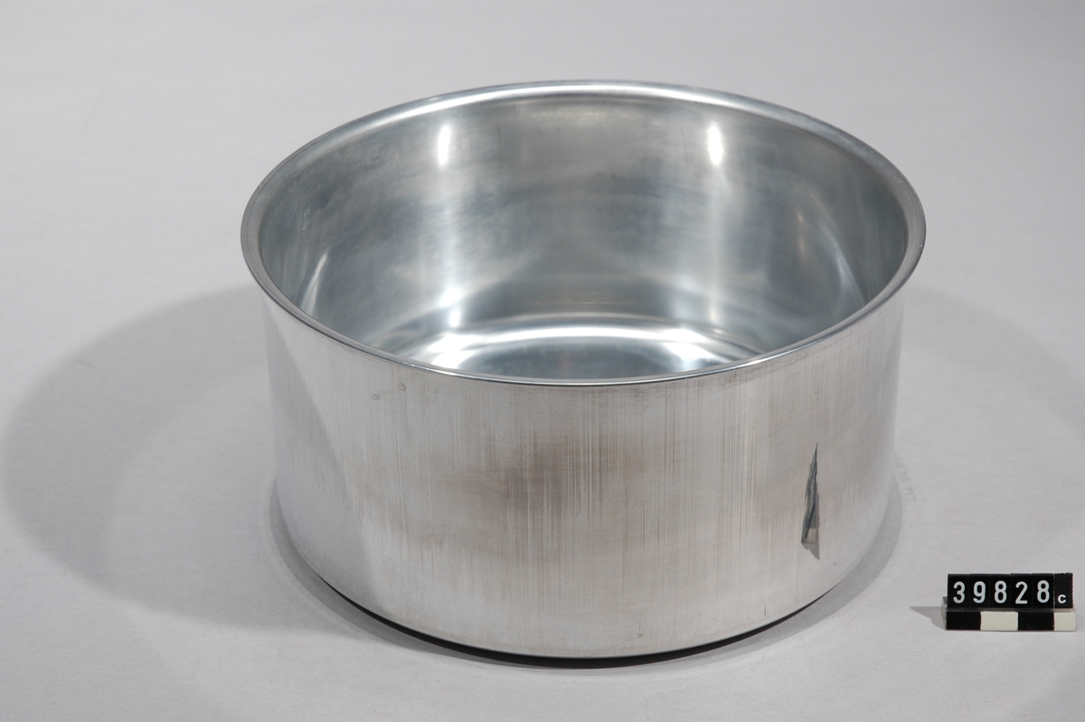Består av 8 delföremål, märkta TM39828:a-h, som visar kallpressning av aluminiumplatta till färdig kastrull, belagd med teflon.