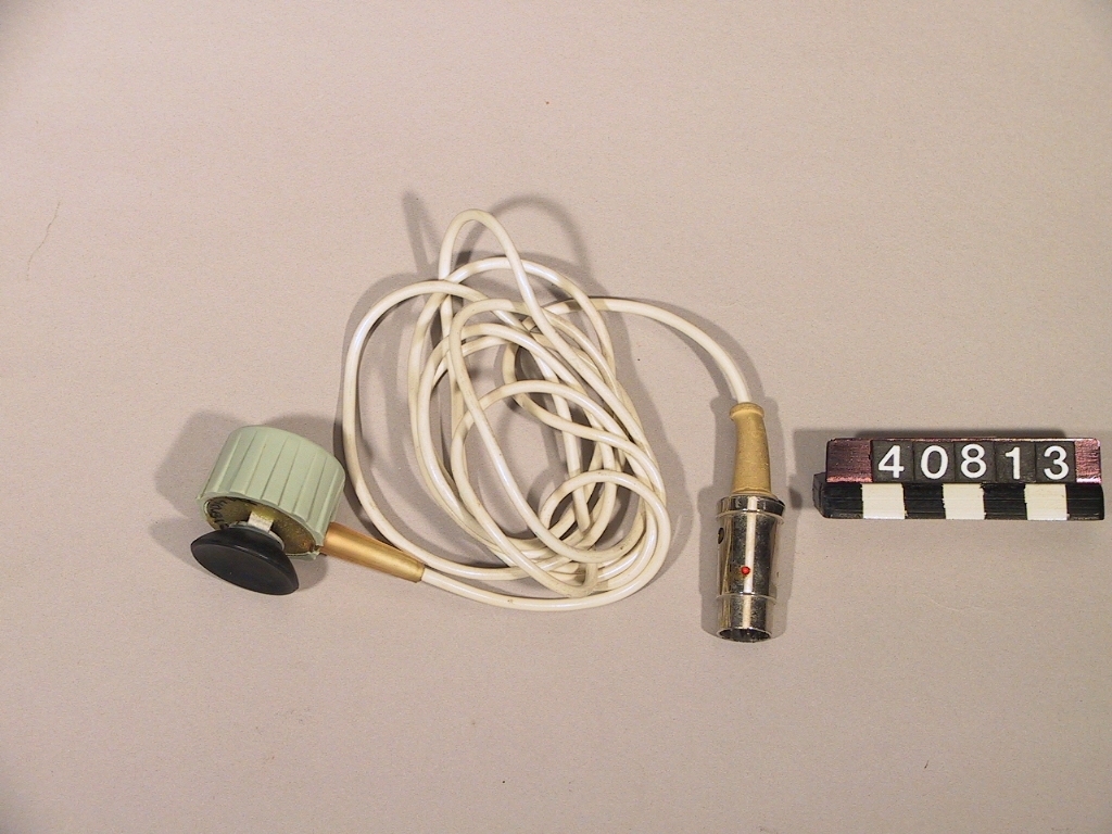 Vit/grön telefonavlyssningspropp för magnetisk upptagning av samtal från telefonapparat, av plast och metall. Till Philips bandspelare modell EL3537/19 1958, med DIN-kontakt.