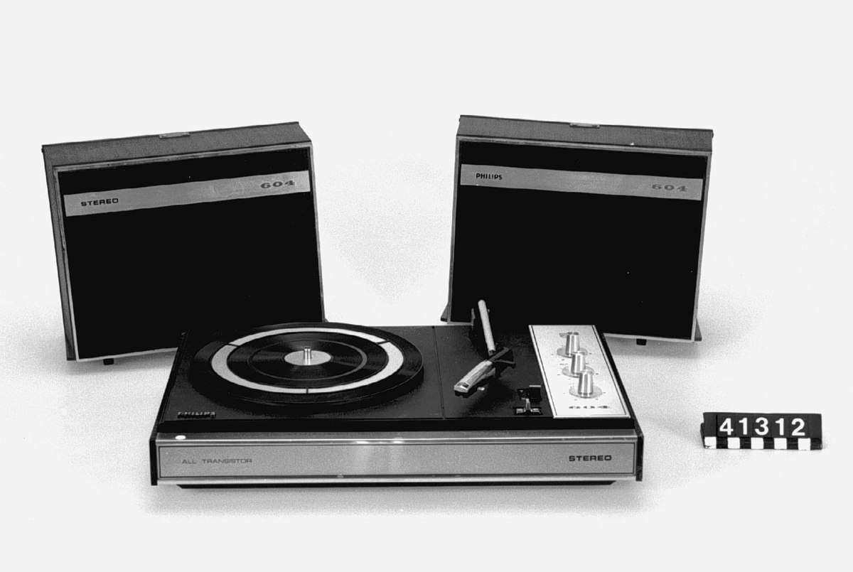 Stereogrammofon för nät eller batteridrift. 78,45 och 33 varv/min. 220 V eller batterier 6 x 1,5 V. Två högtalare som lock (kan tas isär och placeras ut). Heltransistoriserad.