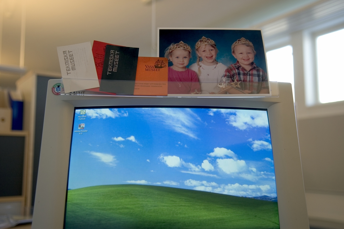 En transparent ficka som fästs på datorskärmens övre del, förvaring för papperslappar.