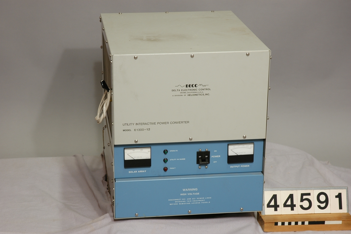 Växelriktare till solcellsanläggning.  Växelriktaren omvandlar likström till växelström och höjer således spänningen till rätt nivå då man ansluter solceller till elnätet.  Text på växelriktaren: " DECC Delta Electronic Control, Irvine, California USA. A division of Helionetics, INC. 2,5 KVA Solar inverter, MFR code 33434, MFR date 8426, Part no 61300-12, Serial no 116, Input voltage 190-250VDC, Output voltage 240VAC, 1Q, 50Hz.