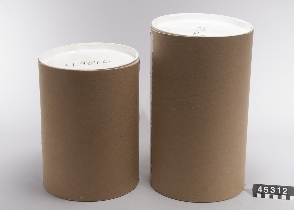 Nedbrytningsbar askurna av patenterat glasmaterial som vittrar sönder efter gravsättning. Då urnan med aska utsätts för markens fukt startar en process som bryter ner glasets grundstruktur. Efter 15 år har glaset omvandlats till grus.  Två urnor - en blå med lock av glas modell Andante samt en matt vit modell Dolce med lock av trä märkt "Anna Persson *1905 +2005", B-37.  Båda märkta "Mats Jonasson, Målerås".