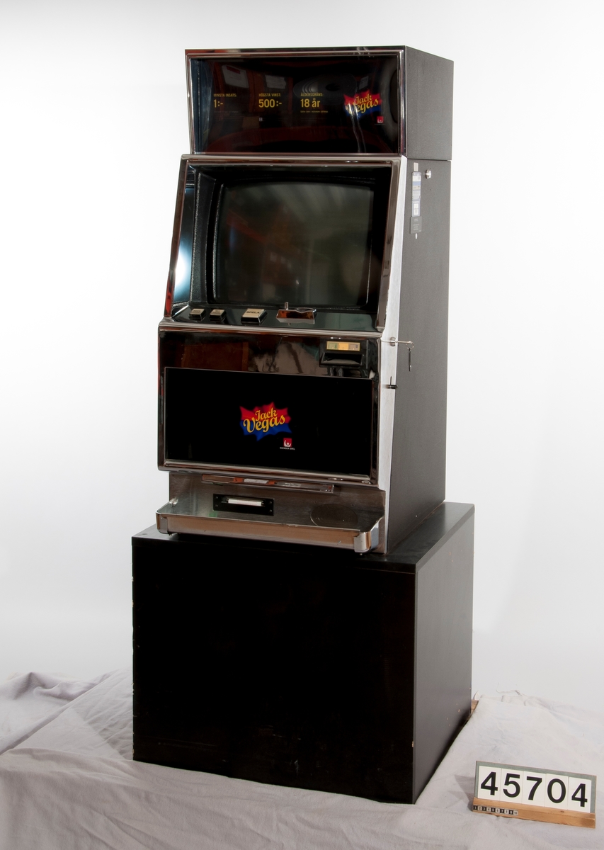 Spelautomat med CRT bildskärm, märkt Jack Vegas. På podium.
En kronas insats, högsta vinst 500 kronor. Åldersgräns 18 år.