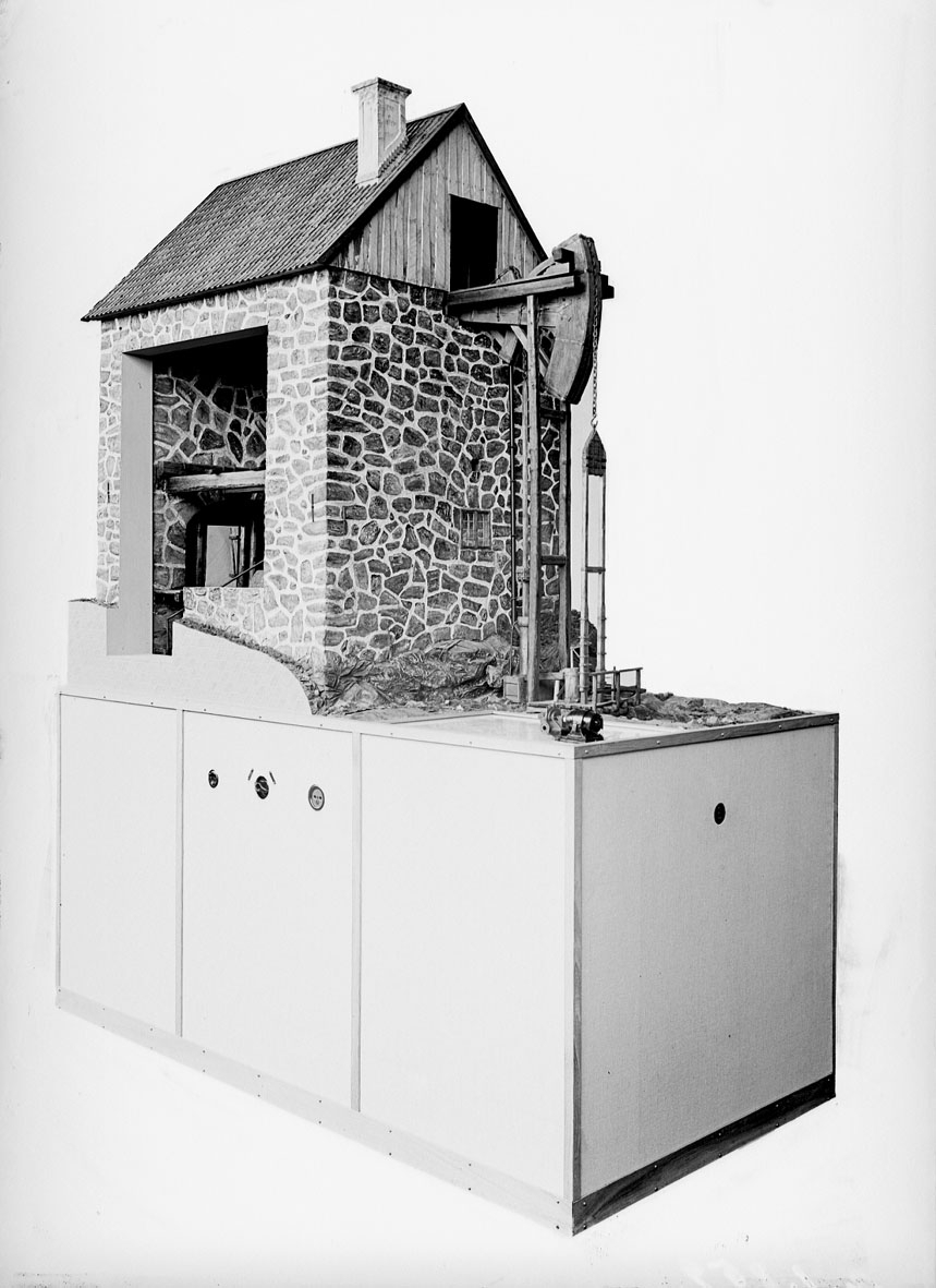 Modell i skala 1:10 av atmosfärisk ångmaskin, "Eld- och luftmaskin". Uppfodrade vid 14 slag per minut c.a. 900 liter vatten från 55 meters djup. Till modellen hör en modell i samma skala av en modern Zeta-pump med samma effekt.