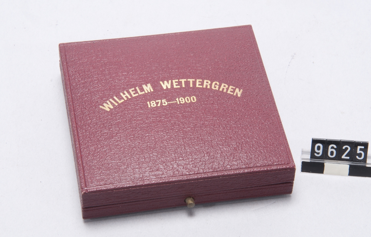 Medalj i silver, över Wilh. Wettergren slagen av Boxholms Aktiebolag. Tilldelad Bruksägaren Wilhelm Wettergren till tack för dennes 25-åriga verksamhet inom Bolaget 1875-1900. Graverad av E. Lindberg. Åtsidan: Porträtt vänster relief, däröver: "Wilhelm Wettergren". Frånsidan: "Tre manliga figurer med skogsbrukets, järnhanteringens och jordbrukets emblem, runt om: "Boxholms Aktiebolags tacksamhetsgärd för 25 års nitisk verksamhet 1875-1900. I endrägt till gemensam förkofran". I etui.