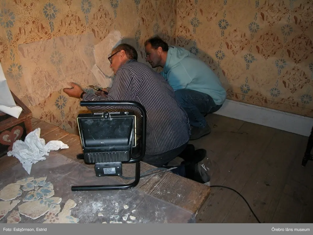 Renovering av Siggebohyttans bergsmansgård 2004-2006.
Främre stugan, interiör. Bror Frigren, ÖLM och konservator Gabor Pasztor i arbete på norra väggen.
Dnr: 2004.600.077