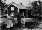 Familjegrupp fem personer.
Bostadshus i bakgrunden.
Banvakt Gustav Petterssons familj.