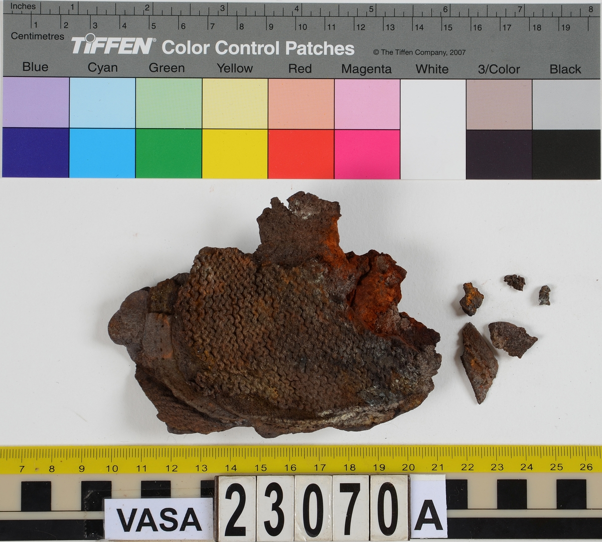 Sko.
Inuti skorna hittades även fragment från olika textilier som ursprungligen varit ett par strumpor. Idag sitter ett stickat fragment av ull fast i vänsterskon (23070) med avigsidan uppåt. I fyndet finns även en mängd lösa stickade fragment som idag är mycket korroderade och vissa helt mineraliserade av järn vilket har gjort textilen stenhård och därmed oerhört skör (23070a-c). Utifrån minskningar som några små fragment har så har det varit möjligt att rekonstruera strumpans tå. Genom att pussla ihop fragmenten som ursprungligen har suttit ihop har det på så vis gått att avgöra hur strumpans tå har varit konstruerad. Då textilen är så fragmentarisk är det inte möjligt att avgöra hur resten av strumpan har sett ut eller varit konstruerad. Däremot så finns det fragment av ett kypertvävt tyg av ull som på vissa ställen ligger dubbelt med det stickade 23070c). Ett av dessa fragment har stelnat i formen så som den suttit på fotens främre del inuti skon. Detta fragment täcker delvis det stickade tyget och har dessutom spår av kaststygn längs en kant. Så som det vävda tyget är placerat på det stickade tyget pekar på att man använt det som lagningslappar till sina stickade strumpor. 
I fyndet finns det även korroderade järnklumpar, ett tuskaftsvävt tyg av ull och rester av ett grovt bastfibergarn och två mindre läderfragment (23070d-f). Det är möjligt att även dessa har tillhört strumpan och/eller skon.

För mer detaljerad information från textildokumentationen (år 2022) se länkade filer.

Skodokumentation 2022:
Ovanläder. Tillverkad i getskinn av god kvalitet. Hör ihop med fyndnummer 23069 (Yngves skor). Tillverkades på en rak läst och bars på vänster fot. Inga dekorationer Det finns stygnhål som visar att det funnits invändiga förstärkningar (men förstärkningslappen saknas). Det finns delaminering men inga lagningar.
För mer information, se Länkade filer: Uppritning

Text in english:
This is the upper of a shoe of more “extreme fashion”, made of goatskin leather of good quality, probably made on a straight last and worn of the left foot, with no decorative features. The upper couples with 23069, together composing Yngve’s shoes. There are internal reinforcements missing from the upper and delamination, there are no repairs.
For more information, go to Länkade filer: Uppritning