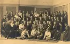 Gruppfoto av fotografer, föreläsare och deltagare i Södra Kretsens andra fotografkurs den 21-23 oktober 1919, översta raden, Fr. Pålsson Höör, S. Erlich Malmö, Fr. L Johansson Wäxiö, O Träff  Markaryd, Fr. E. Käck Ronneby, N Svensson Kristianstad, Fr. Ekstrand Kattarp, A. Föjer Eslöv, andra raden uppifrån, N Gisselqvist Malmö, A Bengtsson Hessleholm, Fr. S Hagman Åstorp, A Lundahl Malmö, Fru H Sundböll Höör, K Olsson Simrishamn, S Ohm Malmö, N Th Christensson Kristianstad, H Piil Hessleholm, Gellström Malmö, Fr. I Östergren Trelleborg, J Johnsson Trelleborg, W strandberg Teckomatorp, S Andersson Malmö, A Karlsson Hästveda, tredje raden uppifrån, A Carlbourn Ystad, Fr Esbjörnsson Tomelilla, Fr Carlie Ronneby, Fr. I Eklund Lund, A Hansson Röstånga, Fr H Ohrling Anderslöv, Fru Sandgren Landskrona, Herr Sandgren Landskrona, Fru Z Borgström Trelleborg, J Berntsson Malmö, A Schmidt Malmö, E A Liljeroth Kristianstad, O Larsson Kristianstad, R Eriksson Engelholm, A Erichsen Karlskrona, F Weyer Malmö, fjärde raden uppifrån, L P Sörensen, P Bagge Lund, Fru Bagge Lund, H Cederberg Malmö, Fr A Iversen Ljungby, Fru Cederberg Malmö, Hj Rosengren Malmö, L Albert Köpenhamn, Fr A Bengtsson Trelleborg, Fru Flodin Stockholm, Fr J Hammar Laholm, Fred Flodin Stockholm, V Roikjer Malmö, D F Källman Karlskrona, R Küller Malmö, Fru Th Falk Karlshamn, Fr Lekander Ljungby, Fr A Madsén Malmö, femte raden, Fr H Nordberg Hälsingborg, Fr L Engström Hälsingborg, Fr O Käck Ronneby, Fr S Johansson Malmö, P.G.