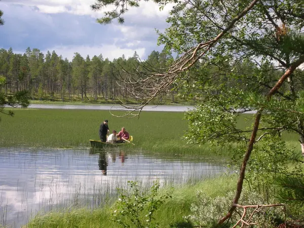 Personer i båt som slår siv