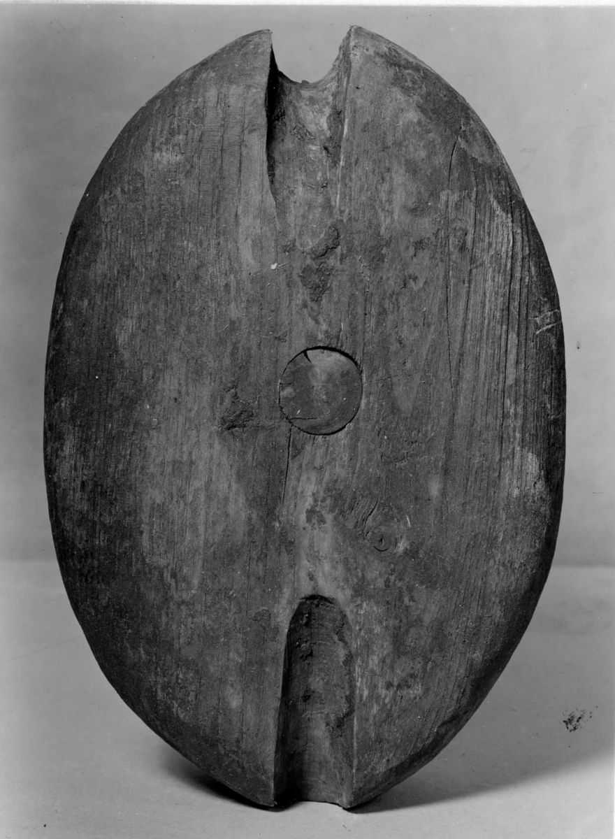 Block hugget ur ett stycke. Platt med rundade kanter. Skölpad kip för stropp. Skiva fäst med tränagel.