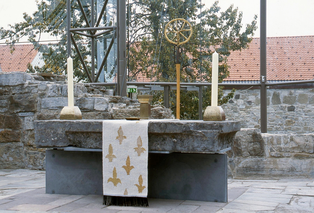 Et av tre verk. Antependiumet (duken) blir brukt under messer og gudstjenester som feires av Den norske kirke og Den katolske kirke. Motivet er hentet fra Matteusevangeliet. 6. 26-28 (fra bergprekenen; "Se på himmelens fugler (...) Akt på liljene på marken...")
Verkets hovedfarge er hvit med innslag av sølv. De franske liljene er i gull. Liljen skal symbolisere den hellige treenighet og Maria, Jesu mor. Den hvite fargen står for renhet, hellighet og uskyld.