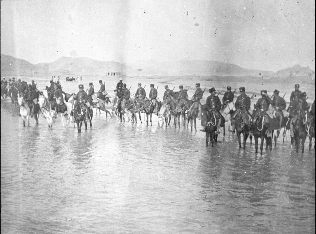 "Gendarmer till häst". "Från Chiraz-expeditionen [Shiraz] i mars 1913" - kanske det ska vara 1912? Samling vid ett vattendrag.