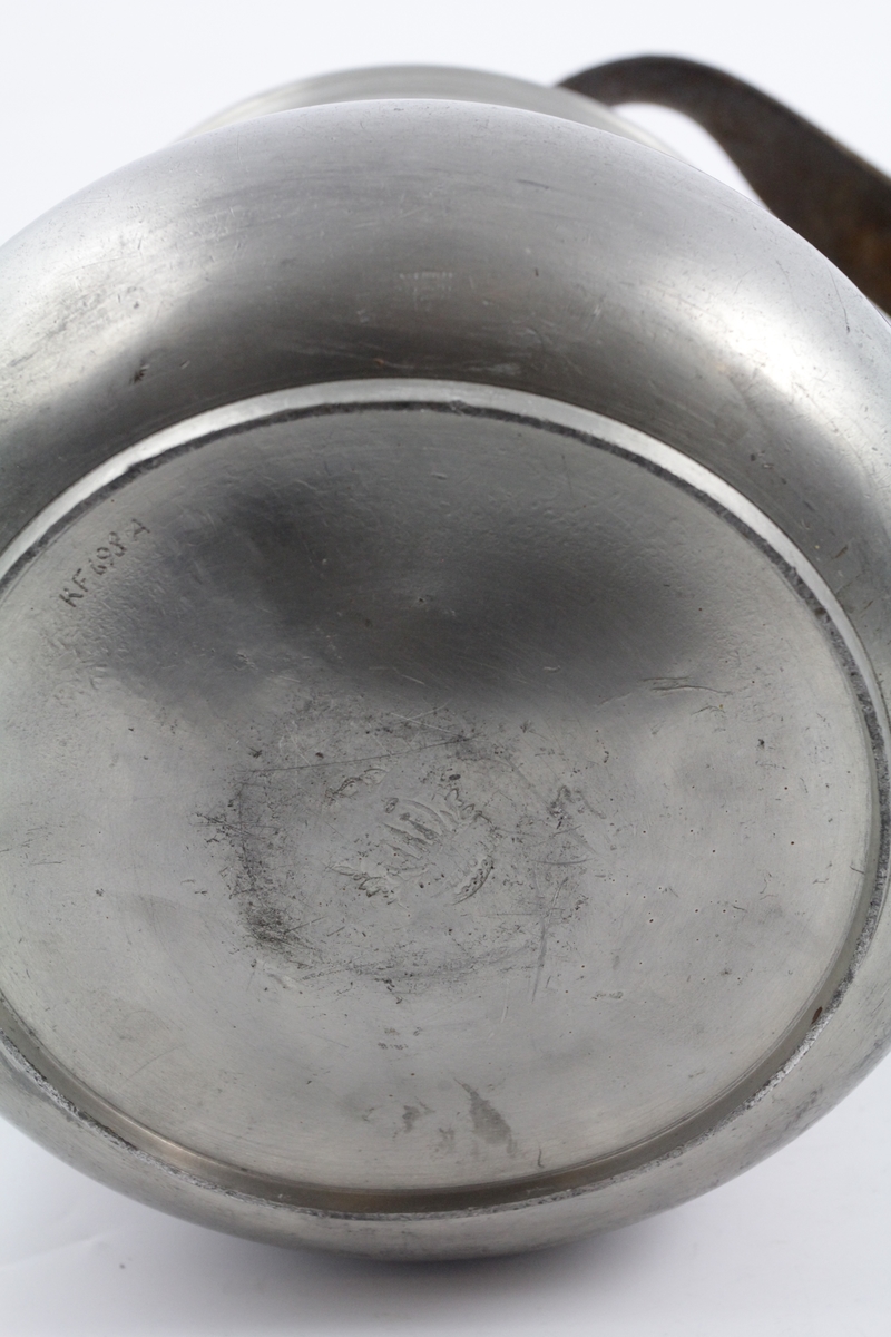 Matspann av fire deler og bærerem. 

a: Beholder. Nederste. Sirkelrund bunn med lav fotring, utbuket side, innsnevret rand. To bøyleformede hanker over snelleformet knapp. 

b: Beholder. Midtre. Sirkelrund. Svakt hvelvet bunn, med horisontal kant. vertikal side profilert ved kanten, og forsynt med to rettvinklede ører. 

c: Beholder. Som b. 

d: Lokk. Sirkelrundt, hvelvet, prydet med to konsentriske linjer, horisontal kant og dreiet knapp av tinn og tre. 

e: Rem. til å bære og forbinde delene. Lær, brun, flat med fire spaltelignende hull.