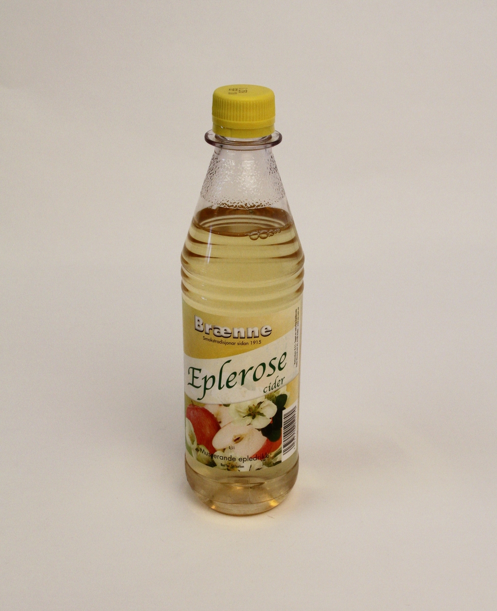 Brusflaskene har begge ein etikett med bilete av epler og epleroser på gul bakgrunn. Produktnamn på skrå over etiketten. Alle trykt skrift i svart.